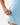 Close up on the zippered pocket on the Sky Blue Momentum Shorts on a model in front of a light gray background.
