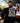 Male model wearing the Slice of Death Long Sleeve T-Shirt at a Brewery with greenery and people in the background