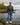 Male model wearing the Squatch Wildknit Sweater outside standing on a shoreline with a lake and trees in the background.