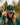 Model wearing the Stag Waxed Canvas Hat outside doing a hat tilt, with greenery in the background.