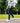 Model wearing the Ace Pants outside with greenery in the background