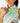 Close up on the collar of the Real Dill Sleeveless Polo on a model in front of a light gray background.