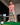 Model wearing the Boy's The Reef Polo at a golf simulator getting ready to hit.
