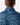 Close up on the Waggle Patch on the back of the Up North Twilight Quarter Zip on a model in front of a light gray background.