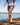 Model wearing the Up North Shoreline Short while walking along the shoreline of a lake.