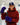 Taylor Fox on an ice rink wearing a burgundy hoodie, a navy blue cap with a white logo, and purple hockey gloves, holding a hockey stick.