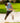 Model wearing the Want S'More Polo on the golf course hitting out of a bunker.
