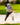 Model wearing the Want S'More Polo on the golf course hitting out of a bunker.