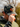 Man holding camo hat, outdoors.