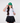 A female model wearing the Wednesday T-Shirt paired with the Ace Flight Hat in front of a gray background.