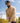 Model wearing the the Wheat Sunday Quarter Zip outside with blue sky & greenery in the background