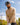 Model wearing the the Wheat Sunday Quarter Zip outside with blue sky & greenery in the background