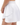 Side profile of the White Flairway Skort featuring the Waggle "W" Logo. Skort is on a Model in front of a white background