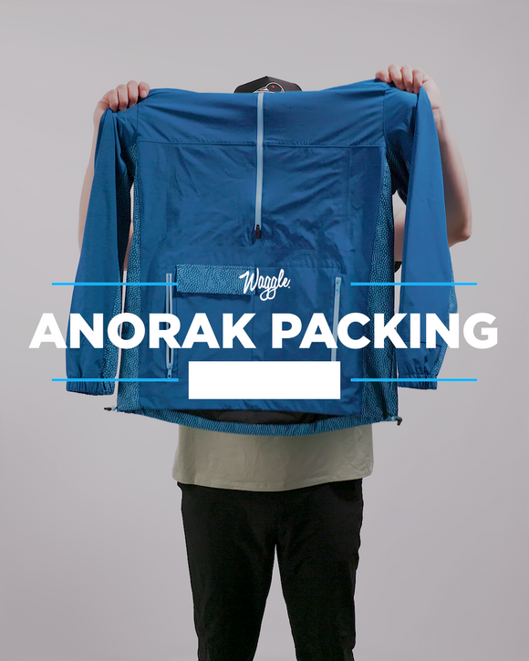 An instructional video on how to pack the Anorak Jacket.  A model is showing that you need to unzip one side of the kangaroo pocket and pull from the inside of the pocket to pack up the jacket.